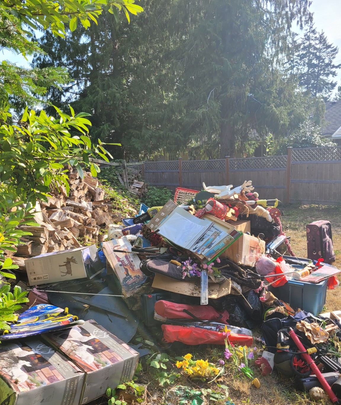 Backyard in Qualicum Beach piled with belongings before an estate cleanout