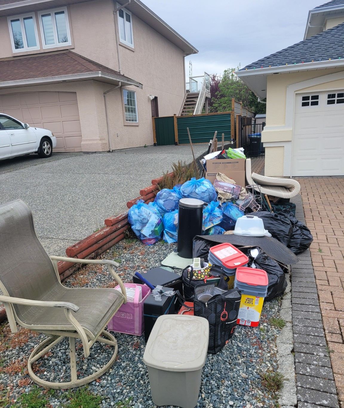 A driveway in Nanaimo stacked with household junk and debris before a Junk Matters pickup