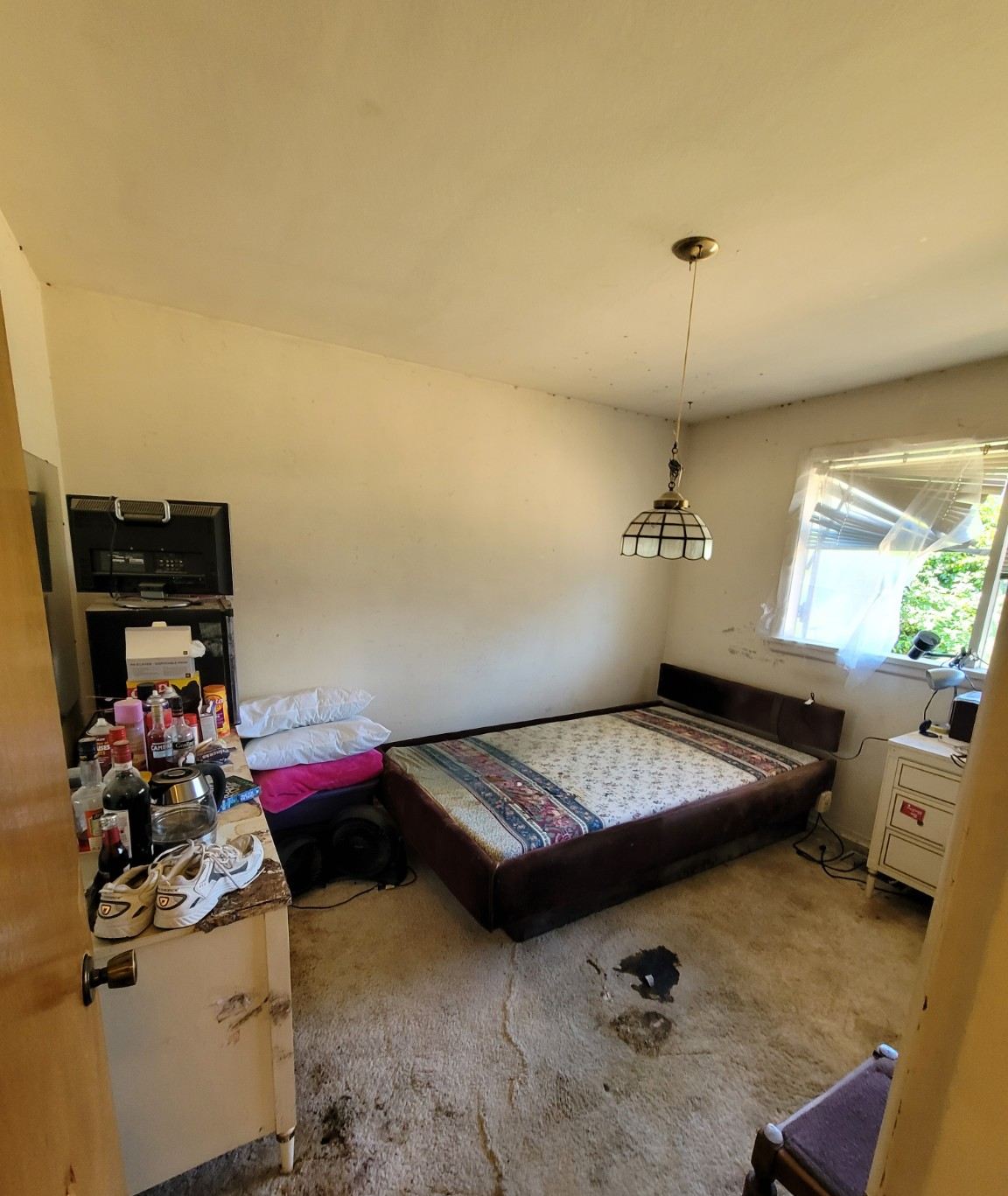 The same bedroom cleared, bed and carpet visible again