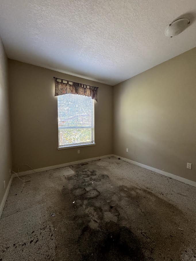 A Nanaimo bedroom with heavily stained wall-to-wall carpet before Junk Matters pulled it out
