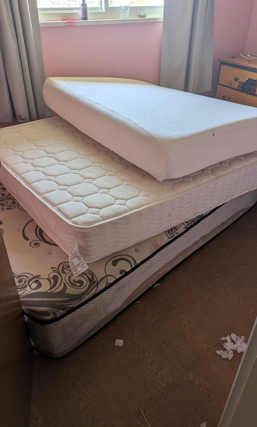 A mattress and matching box spring standing in a Nanaimo bedroom before removal