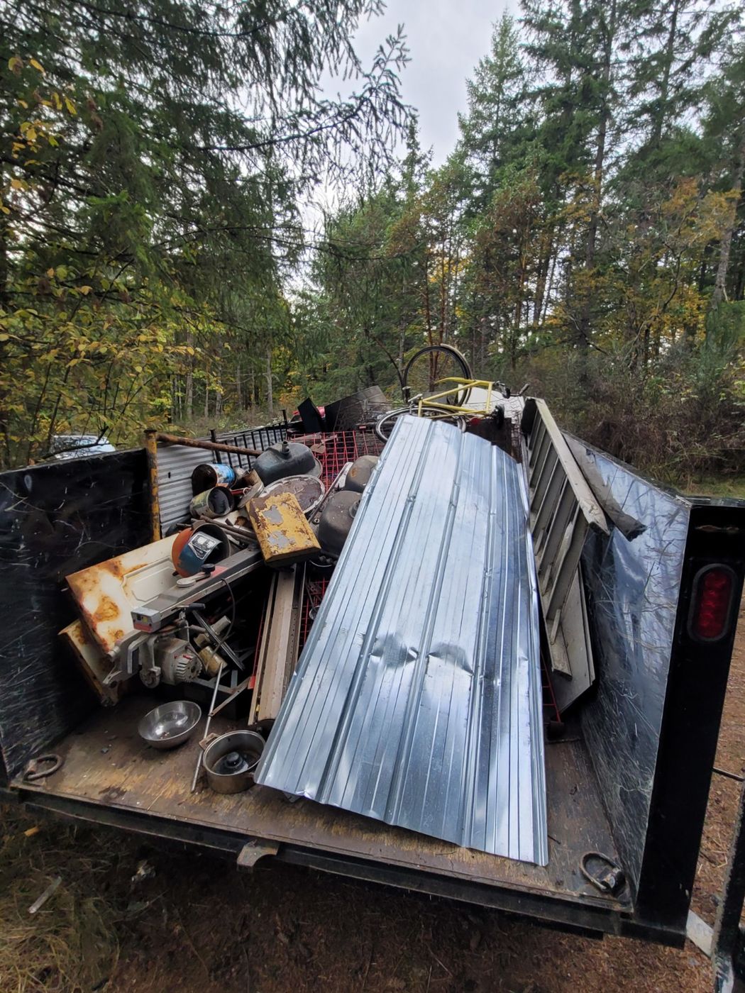 Sheets of aluminium siding and metal offcuts loaded flat in the Junk Matters trailer in Nanaimo